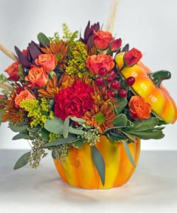 This pumpkin patch would be perfect for any dining room table this fall. With roses, mums, carnations, and seeded eucalyptus and beautiful ceramic pumpkin container.